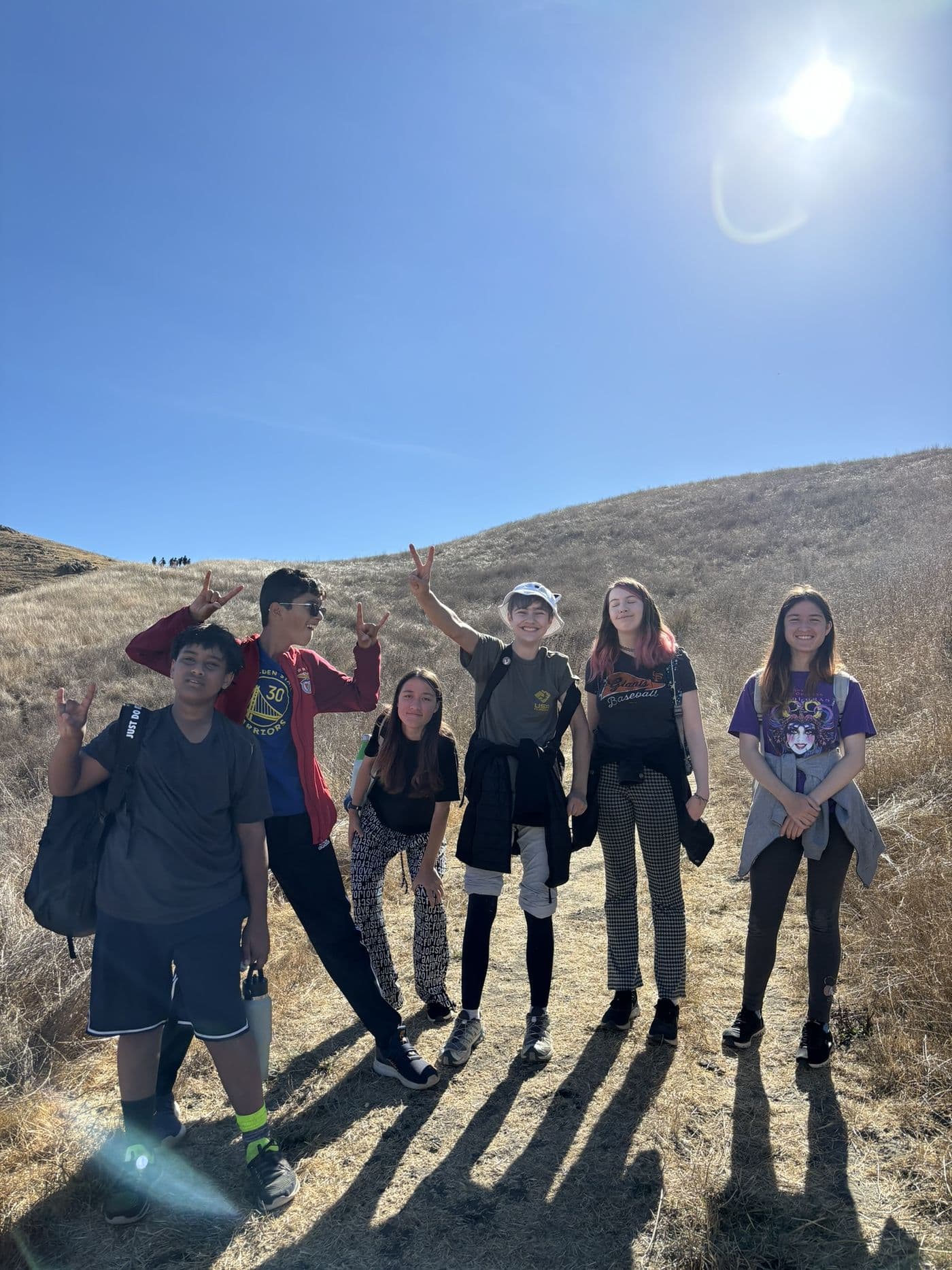 A group of students on a hike in the golden hills